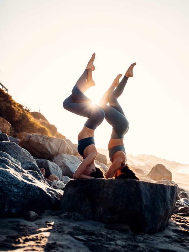 women doing acro yoga together